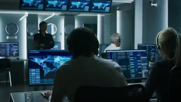 security operations center with multiple screens and operators