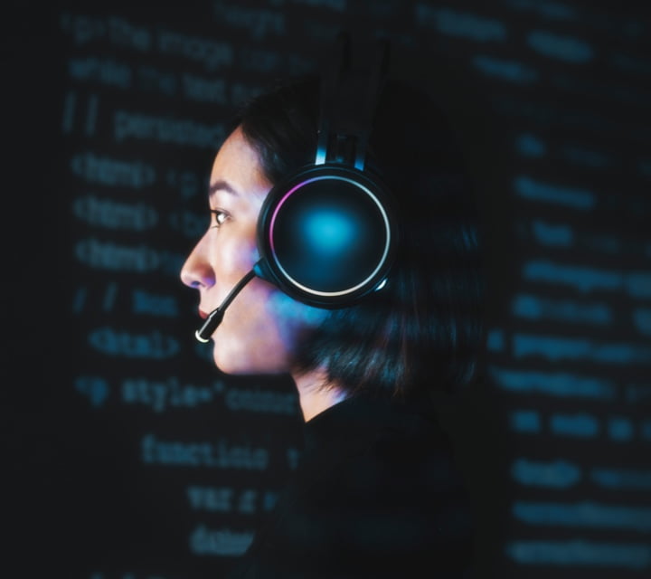 Woman with an operator headset against a backdrop of computer code.